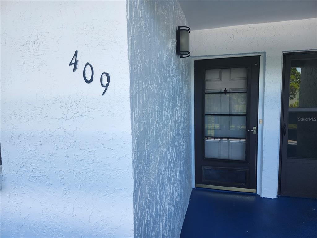 An oval sign labeled Lexington stands in a landscaped garden in front of a building — 5970 80TH STREET N UNIT 409, ST PETERSBURG, FL