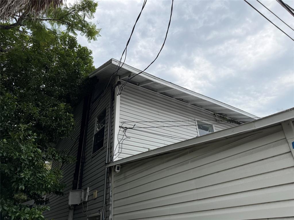 An exterior view shows the side of a two-story house with white vinyl siding — 614 15TH STREET N, ST PETERSBURG, FL