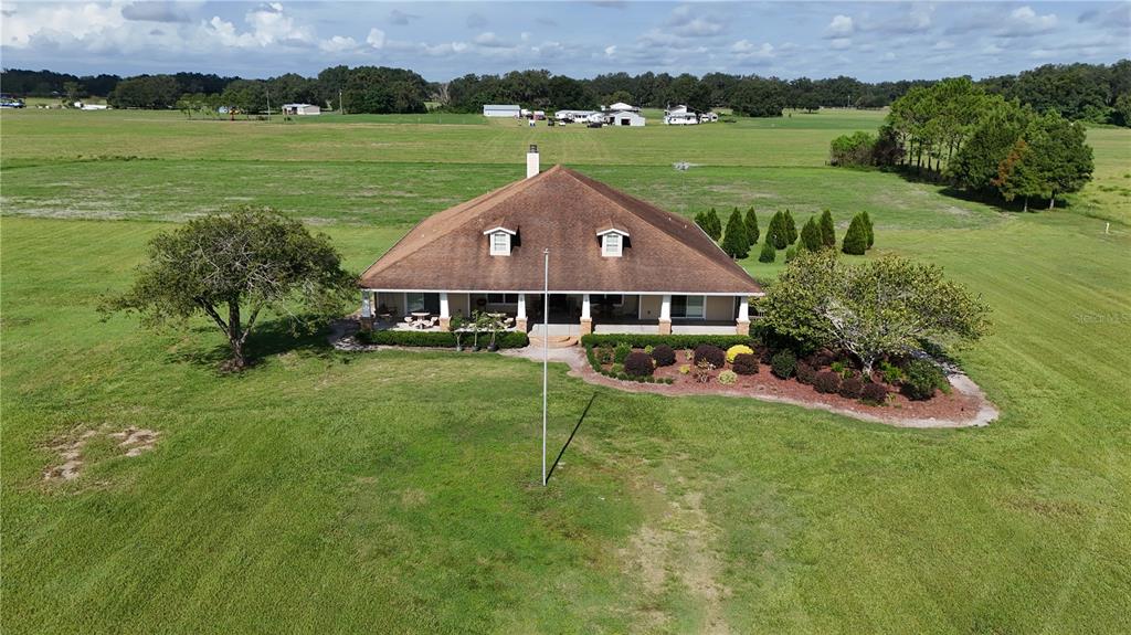 An aerial view of a single-story house with a large hip roof and front porch — 6622 SR 471, BUSHNELL, FL