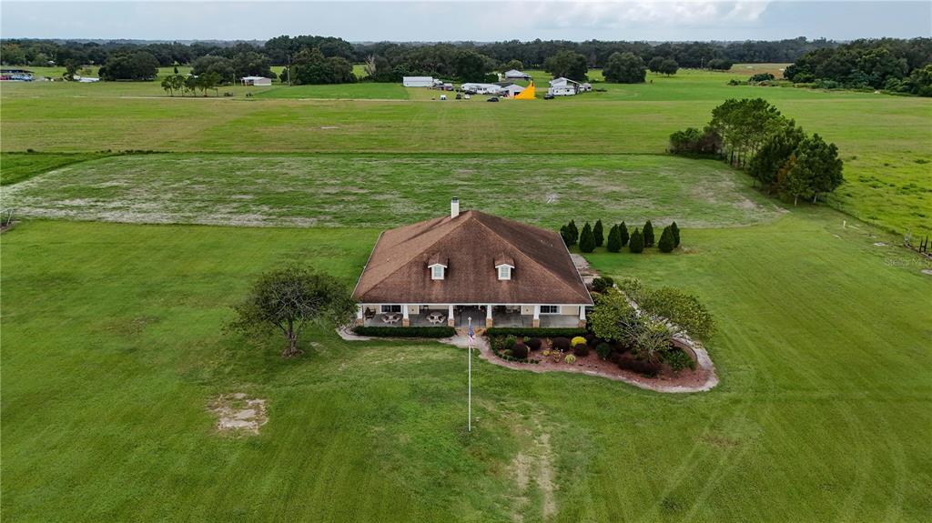 An aerial view of a house with a brown roof surrounded by a large lawn — 6622 SR 471, BUSHNELL, FL