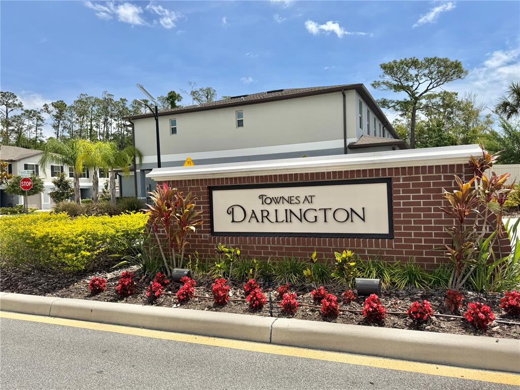 A brick monument sign for Townes at Darlington stands in front of a residential building — 2578 CHARLAN COURT, HOLIDAY, FL
