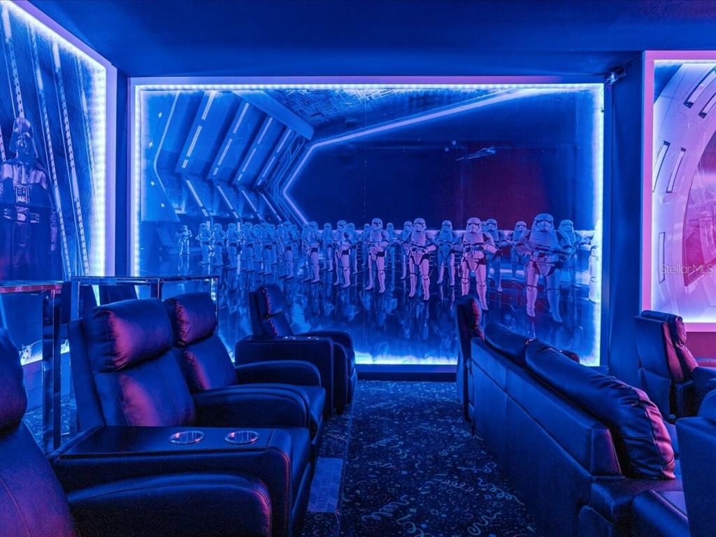 A Star Wars-themed home theater features rows of leather recliners and illuminated wall murals — 5830 HIGH SEAS DRIVE, ORLANDO, FL
