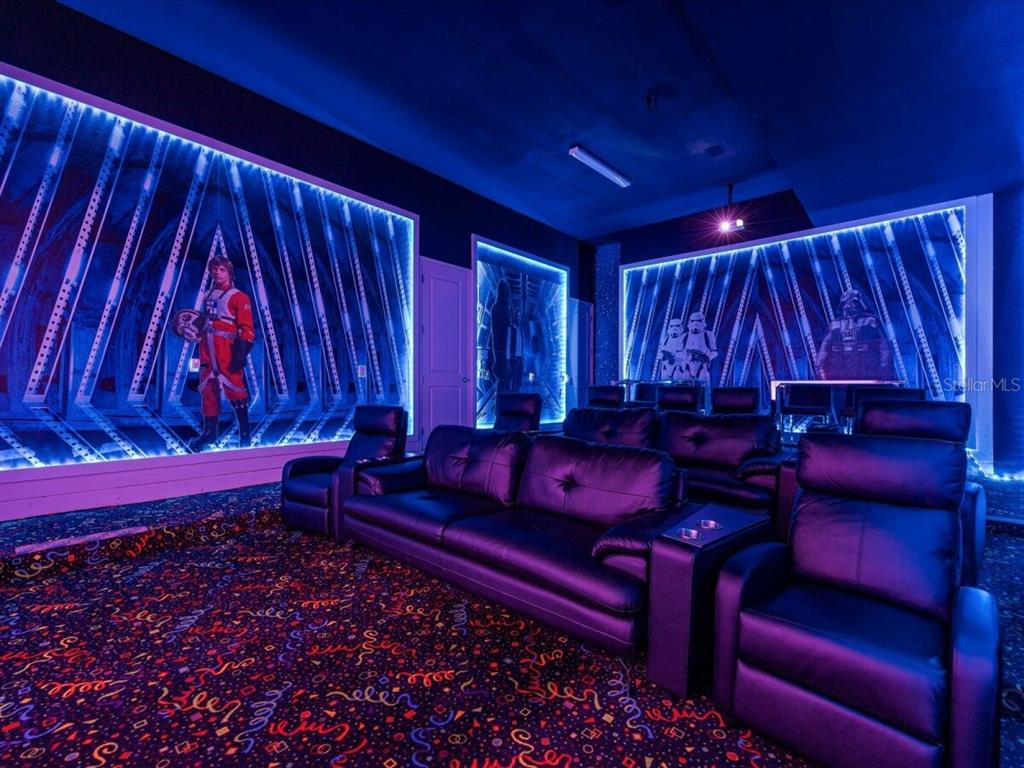 A home theater room features Star Wars wall murals, blue LED lighting, and leather seating — 5830 HIGH SEAS DRIVE, ORLANDO, FL