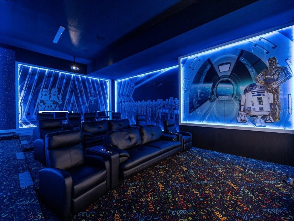A Star Wars-themed home theater features tiered leather seating, neon-lit wall murals, and patterned carpeting — 5830 HIGH SEAS DRIVE, ORLANDO, FL