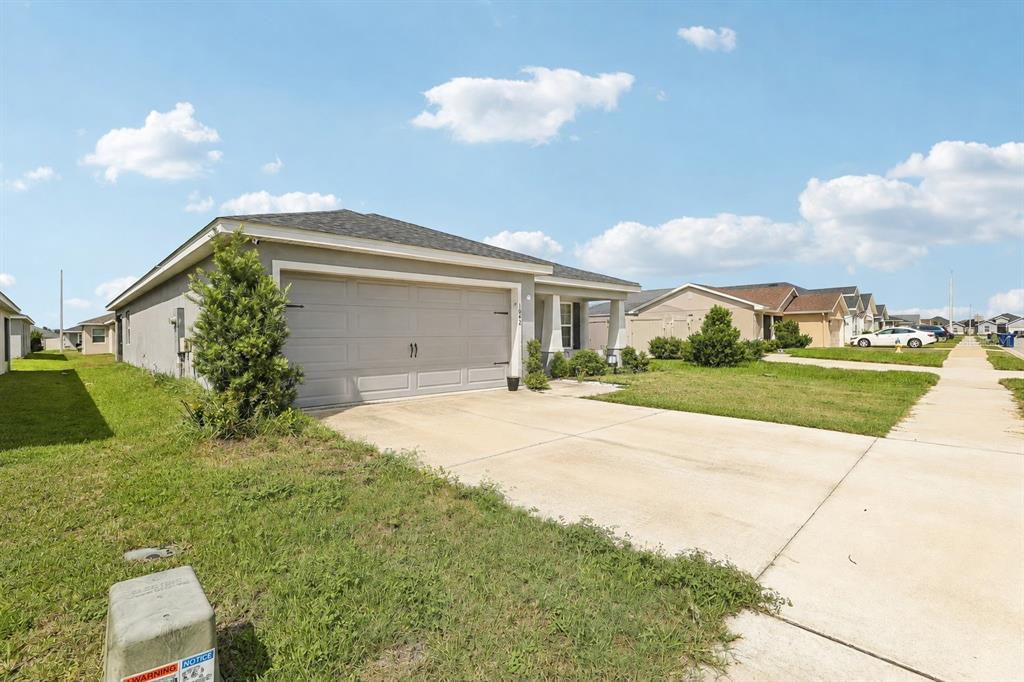 A single-story suburban house with a two-car garage and a concrete driveway — 1042 CORSO DR, WINTER HAVEN, FL