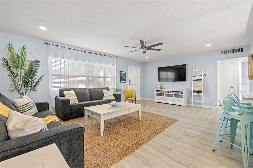 A living room with light blue walls, gray sofas, a coffee table, and a television — 1405 TEMPLE STREET, CLEARWATER, FL