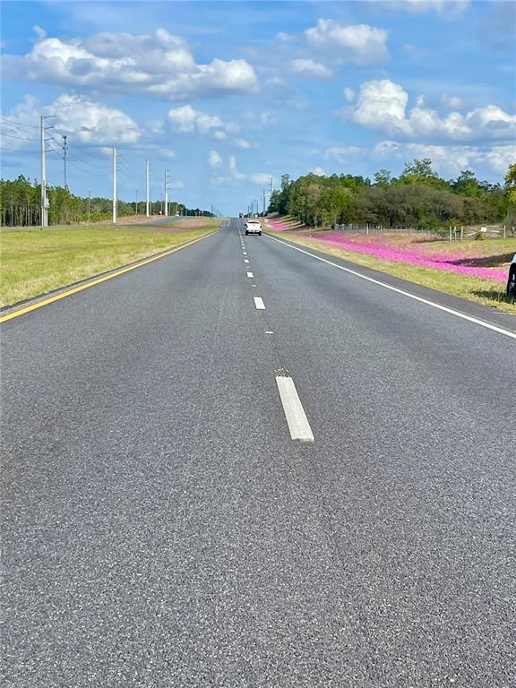 A paved two-lane road stretches into the distance under a blue sky with scattered clouds — TBD NE HIGHWAY 27 ALT, WILLISTON, FL