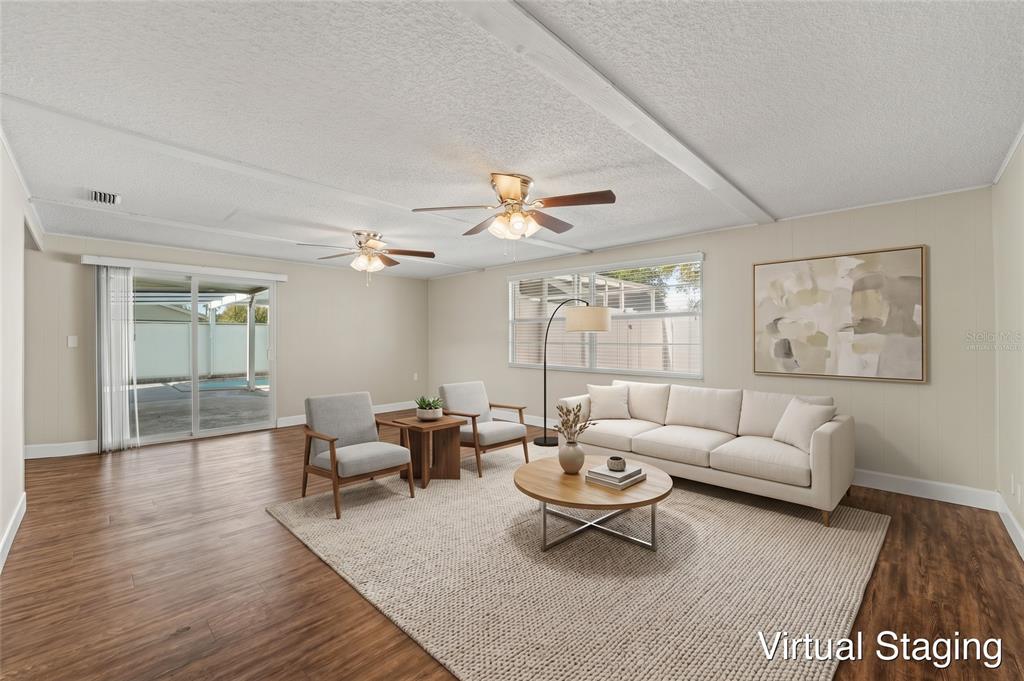 An empty room with wood-look flooring, beige walls, a white door, and a window — 1615 SENECA AVENUE, LAKELAND, FL