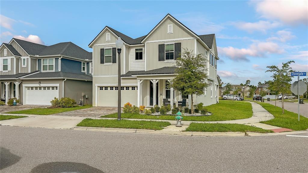 A two-story suburban house with a beige exterior, a two-car garage, and a corner lot — 3107 STONEGATE DRIVE, OCOEE, FL