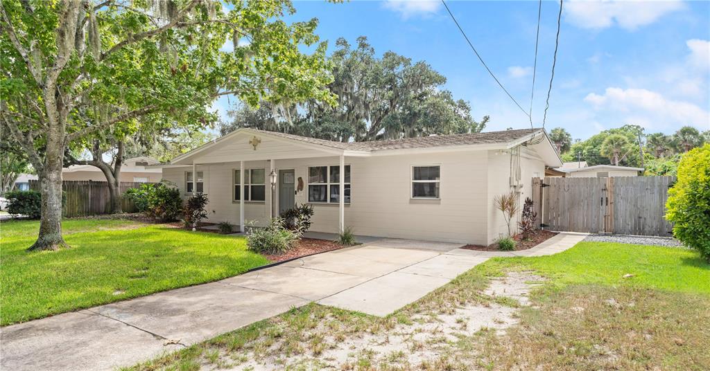 A single-story house with light-colored siding, a front door, and a large tree in front — 358 S ORCHARD STREET, ORMOND BEACH, FL