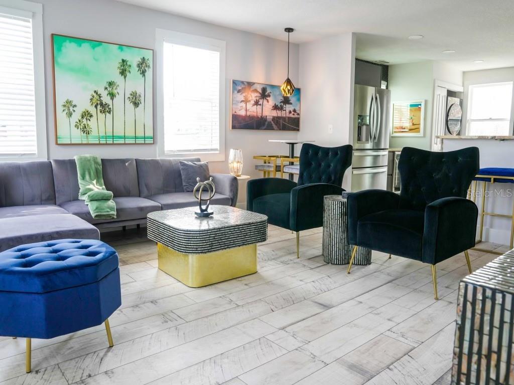 A living room features a grey sectional, two dark velvet armchairs, and a gold-based coffee table — 121-123 N HOLLYWOOD AVENUE, DAYTONA BEACH, FL