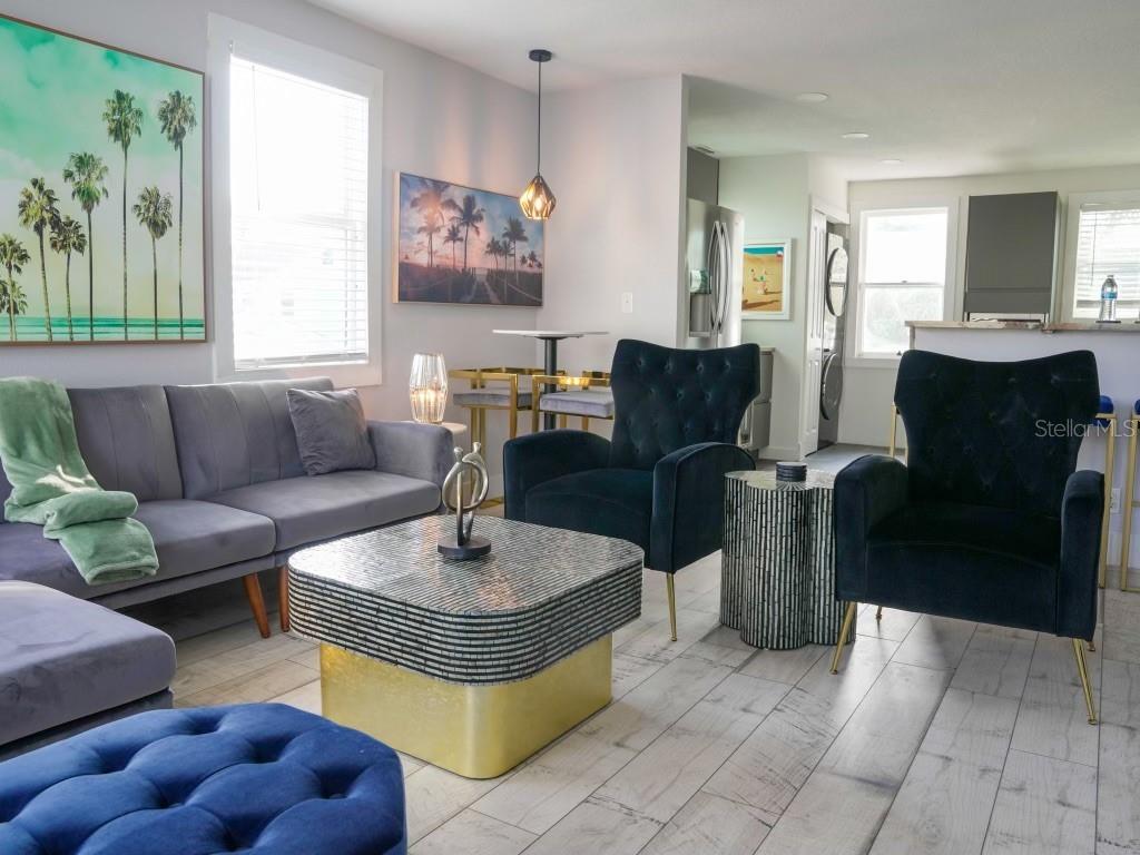 A living room features a gray sofa, two dark blue armchairs, and a gold-based coffee table — 121-123 N HOLLYWOOD AVENUE, DAYTONA BEACH, FL