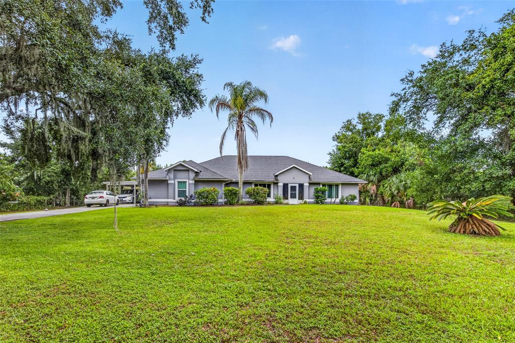 A single-story gray house with a large front lawn and a tall palm tree — 3550 OBERRY ROAD, KISSIMMEE, FL