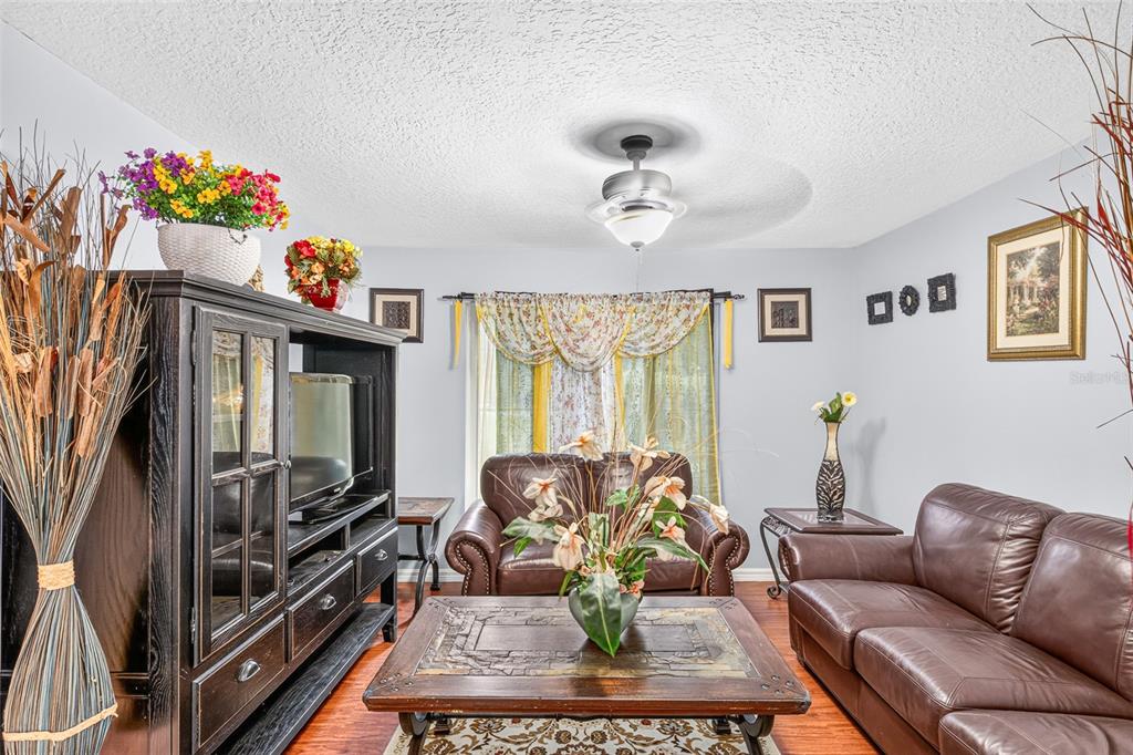 A living room features brown leather sofas, a wooden coffee table, and a dark entertainment center — 3550 OBERRY ROAD, KISSIMMEE, FL