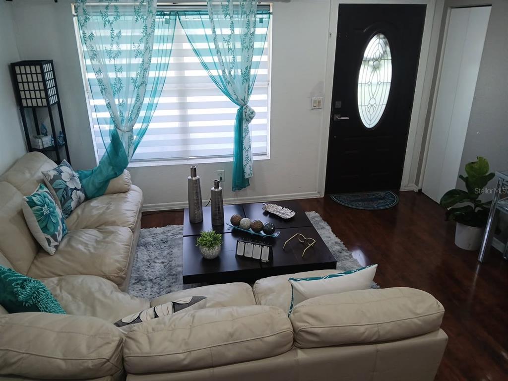 A living room features a white sectional sofa, a dark coffee table, and teal curtains — 14342 SE 45TH COURT, SUMMERFIELD, FL