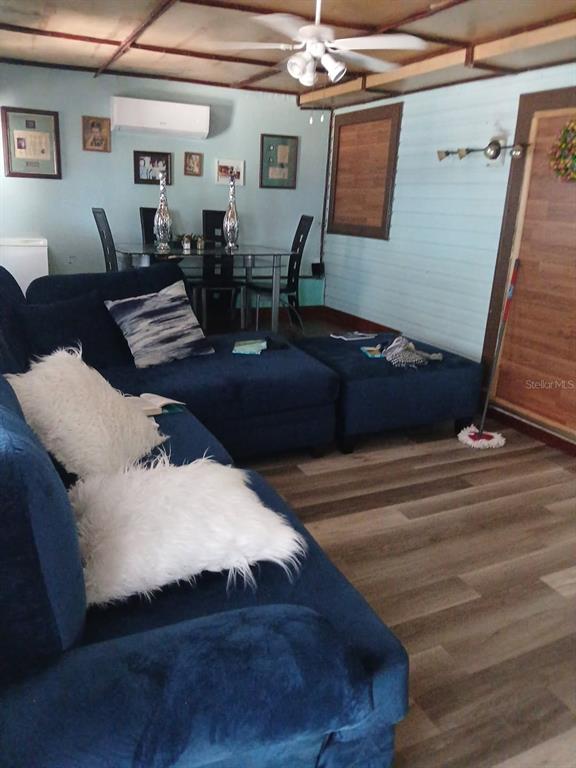 A living room features a blue sectional sofa, a dining set, and wood-look flooring — 14342 SE 45TH COURT, SUMMERFIELD, FL