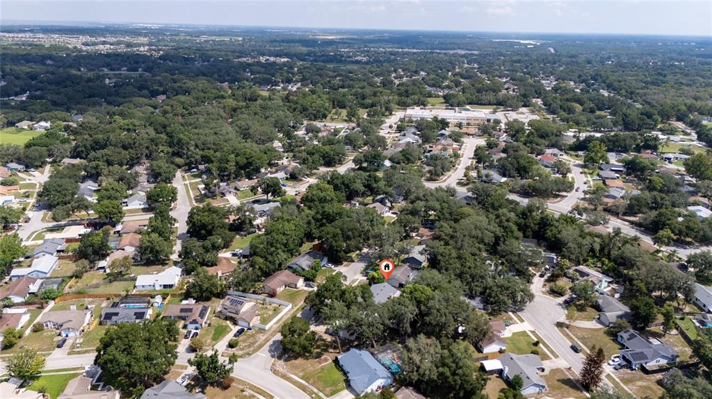 An aerial view shows a residential neighborhood with houses, trees, and streets — 401 HAGER DRIVE, OCOEE, FL