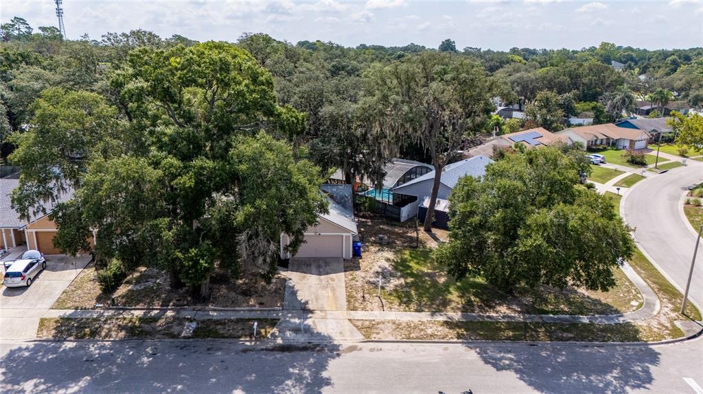 An aerial view shows a single-story house with a garage, pool enclosure, and large trees — 401 HAGER DRIVE, OCOEE, FL