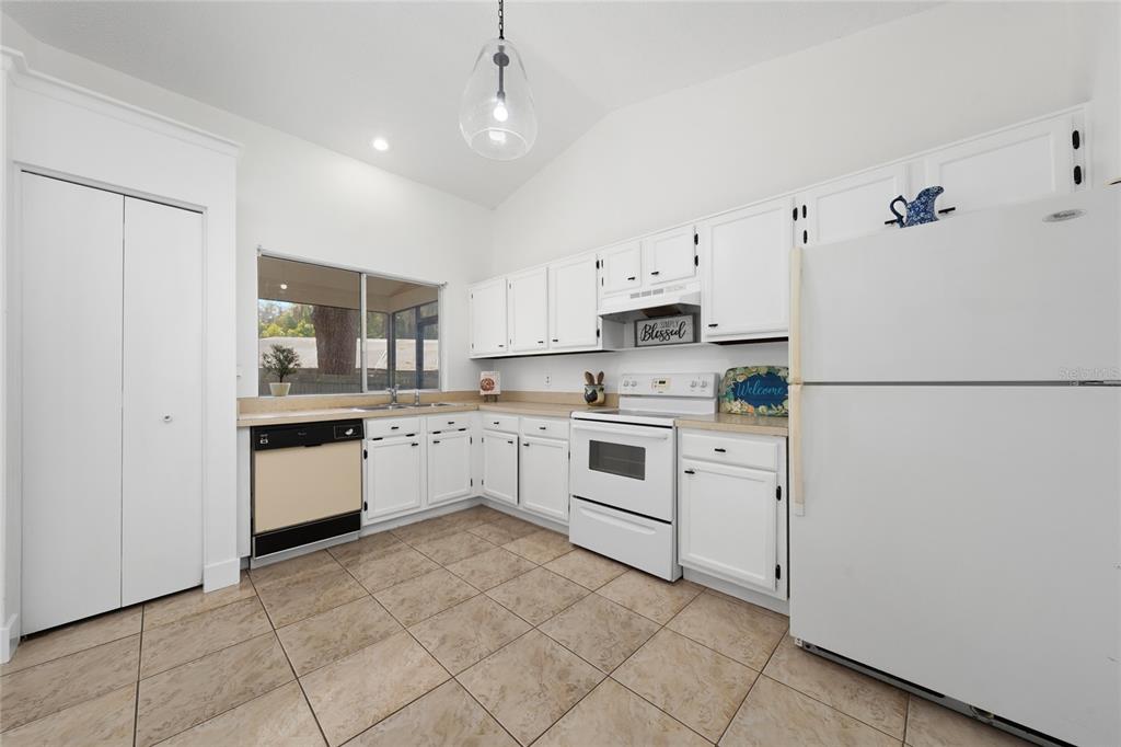 A kitchen with white cabinets, white appliances, tile flooring, and a window over the sink — 401 HAGER DRIVE, OCOEE, FL