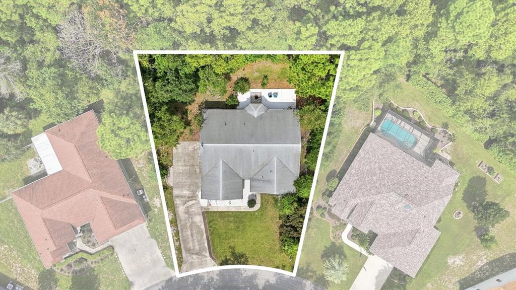 An aerial view shows a house with a gray roof, driveway, and backyard patio — 11 LIDFLOWER COURT, HOMOSASSA, FL