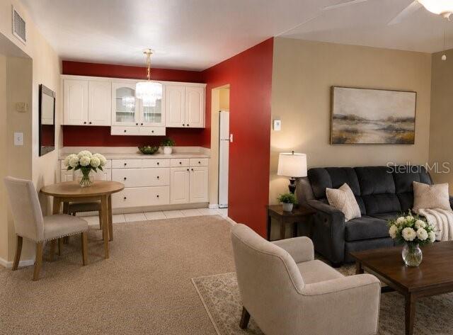 A living room and dining area feature white cabinetry, red walls, and neutral furniture — 1700 6TH STREET NW UNIT C21, WINTER HAVEN, FL