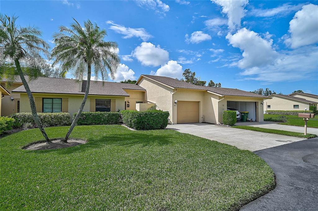 A single-story house with a tan stucco exterior, a two-car garage, and a palm tree — 3189 GLEN ELYN BOULEVARD UNIT 3, SARASOTA, FL