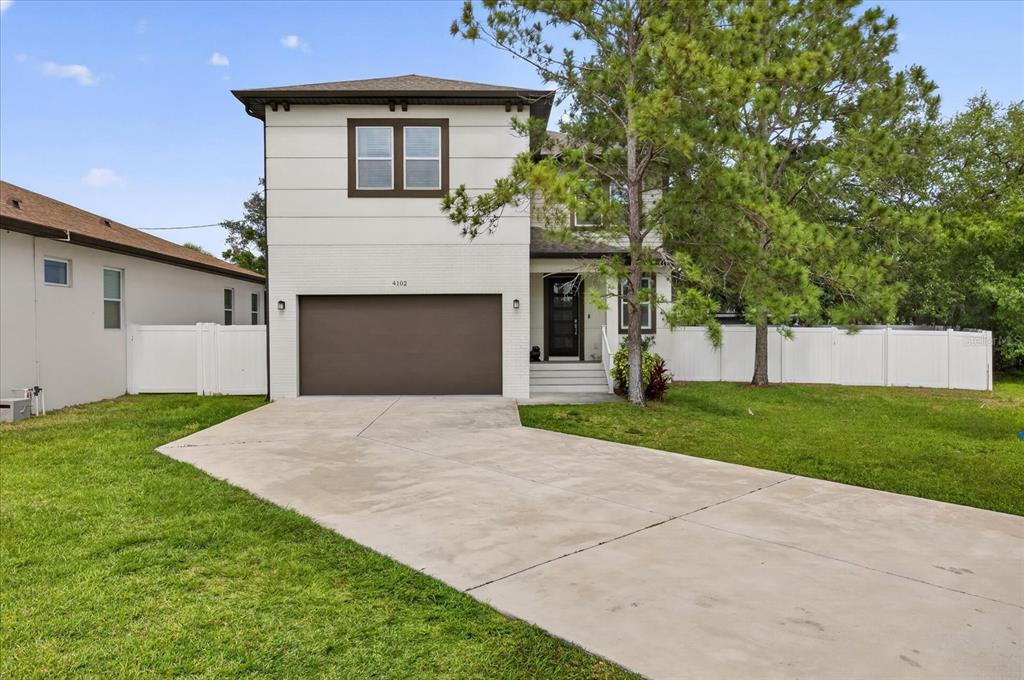 A two-story house with a white exterior, brown garage door, and a concrete driveway — 4102 S TRASK STREET, TAMPA, FL
