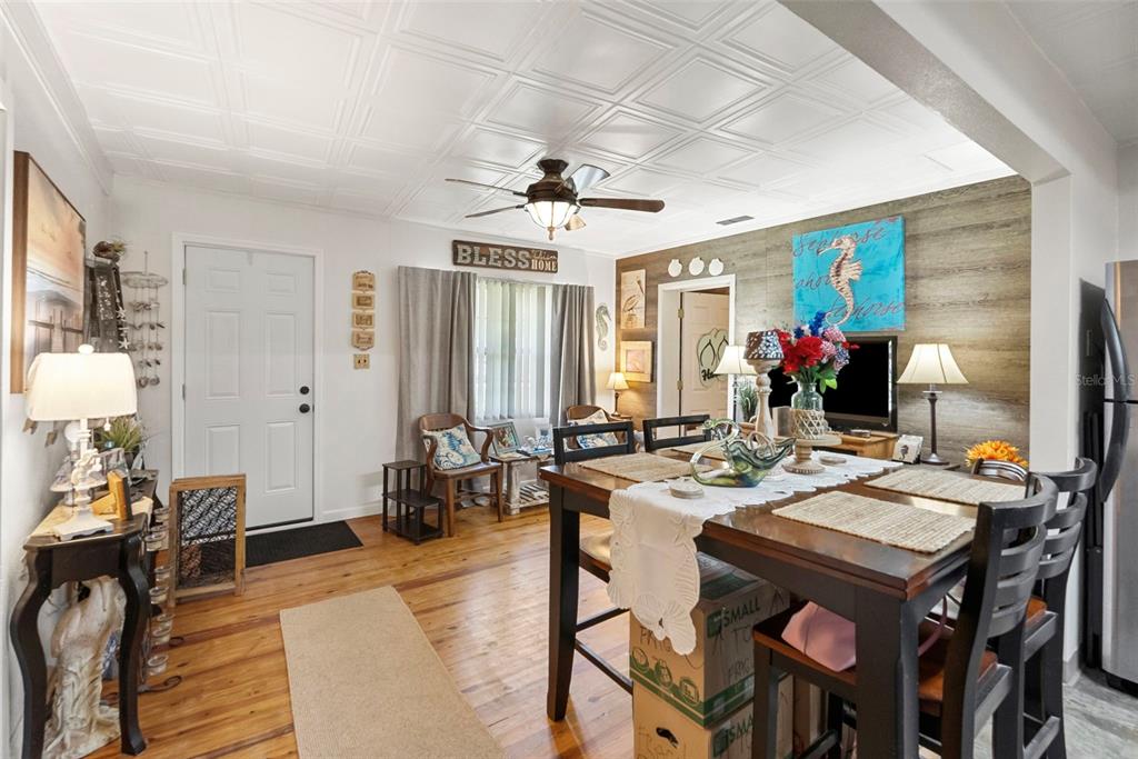 A dining area with wood floors, a coffered ceiling, and a wood-paneled accent wall — 8709 EL PORTAL DRIVE, TAMPA, FL