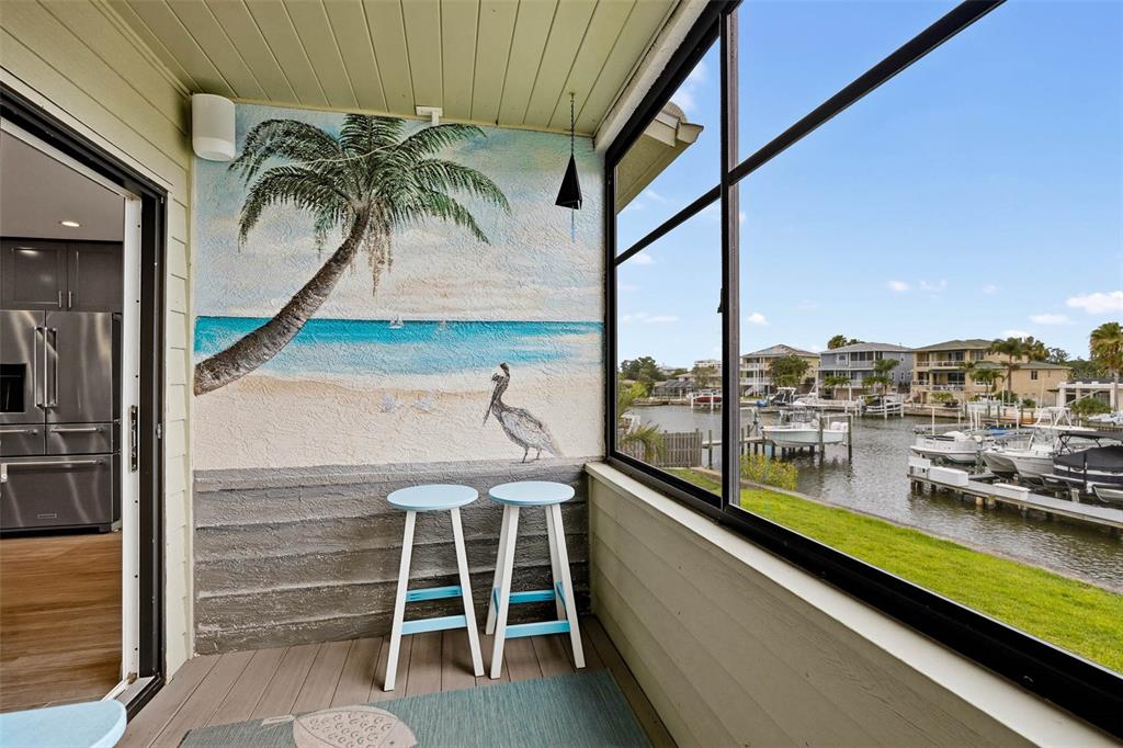 A sunset view over a canal with boat docks, a palm tree, and residential houses — 2395 HANOVER DR, DUNEDIN, FL