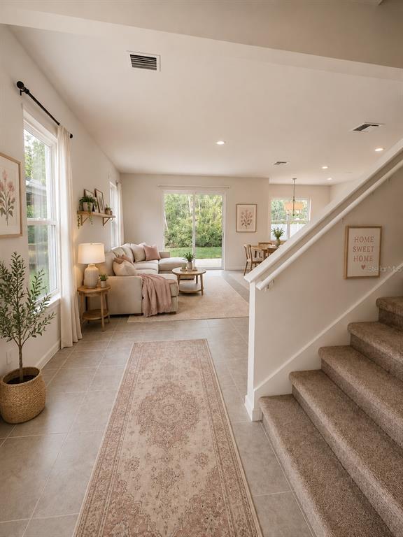 A carpeted staircase leads down to a living room with tile floors and sliding doors — 11931 THORNCREST DRIVE, SPRING HILL, FL