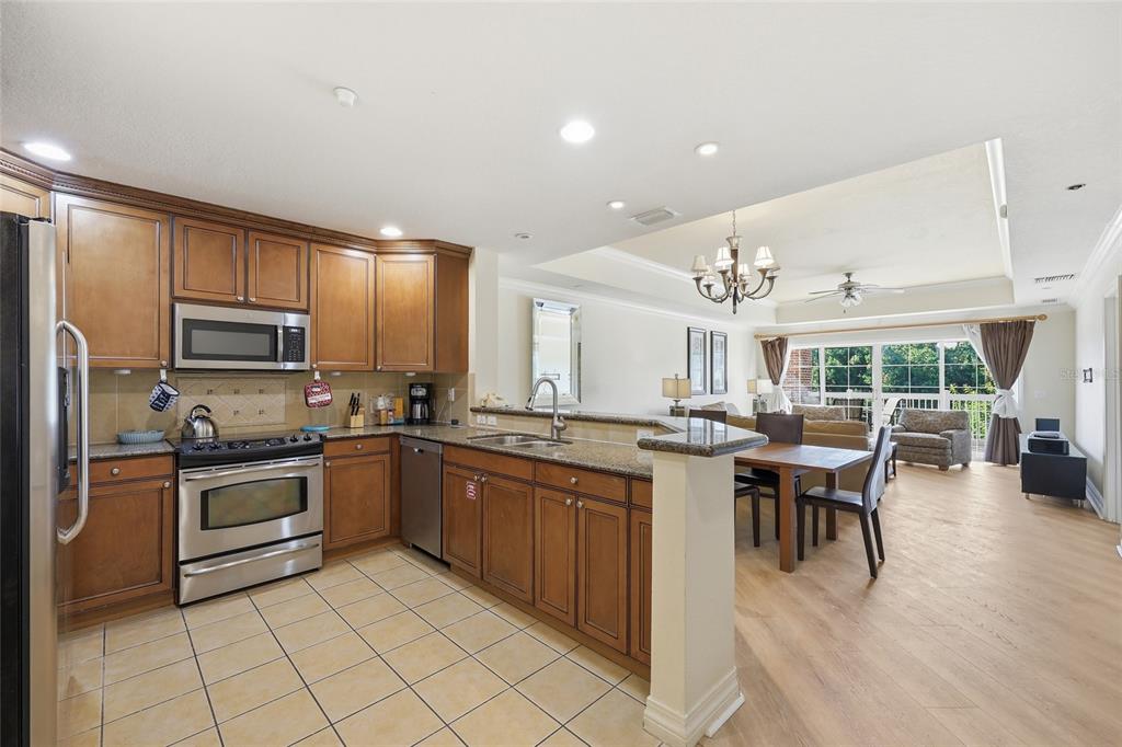 An aerial view shows several multi-story apartment buildings surrounded by trees, parking lots, and golf courses — 7612 CABANA COURT UNIT 202, REUNION, FL