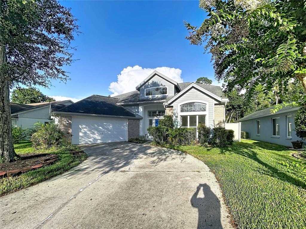 A two-story suburban house with a concrete driveway, a two-car garage, and arched windows — 9122 ROCKROSE DRIVE, TAMPA, FL