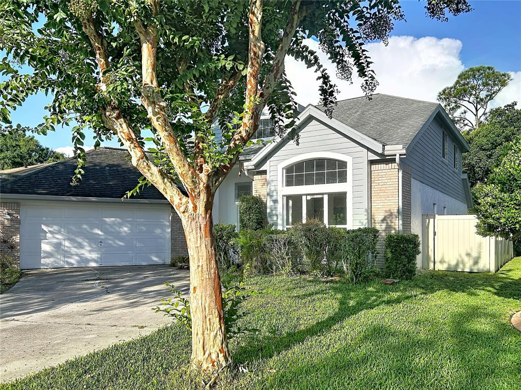 A two-story house with a gray exterior, a two-car garage, and a large front tree — 9122 ROCKROSE DRIVE, TAMPA, FL