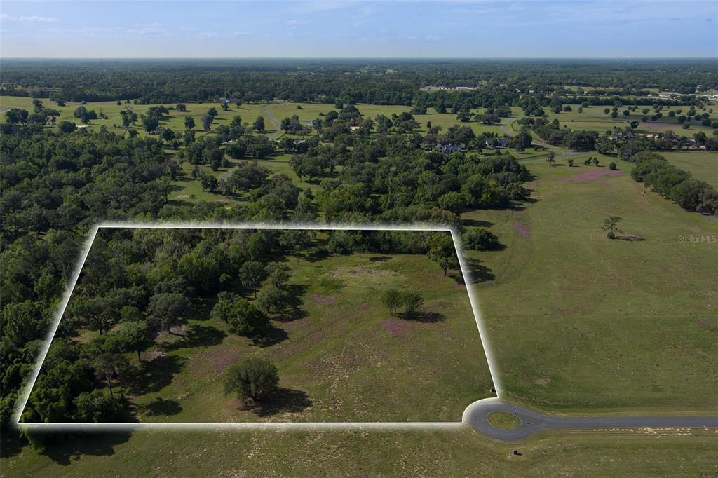 An aerial view shows a vacant, partially wooded lot outlined in white near a cul-de-sac — TBD SE 111TH PLACE, OCALA, FL