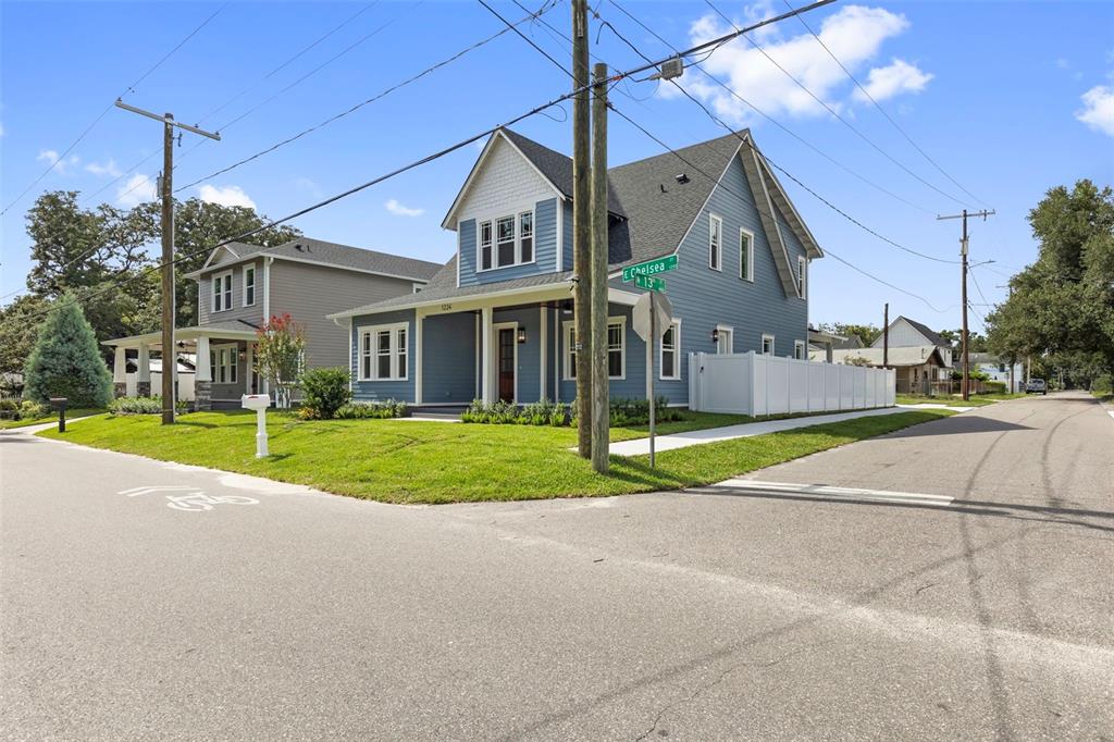 A blue two-story house with a front porch sits on a corner lot — 1224 E CHELSEA STREET, TAMPA, FL