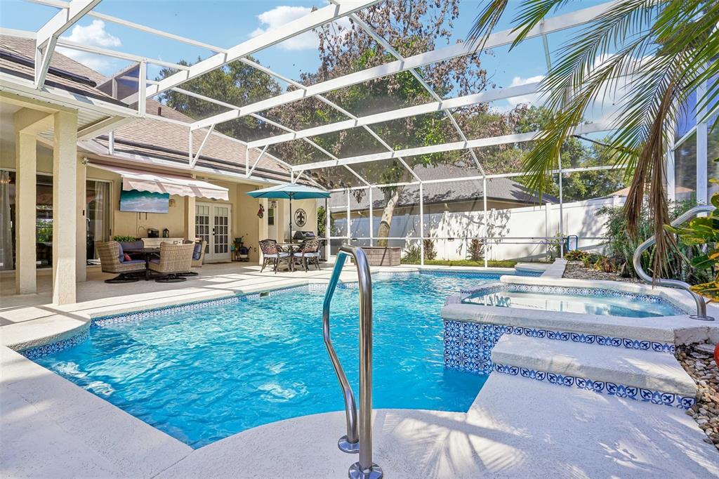 A screened-in patio features a swimming pool, a hot tub, and outdoor dining furniture — 19323 PARK PLACE BOULEVARD, EUSTIS, FL