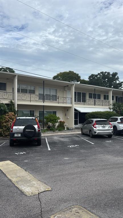 A room with beige carpet, a wooden desk, a shelving unit, and a large window — 4032 57TH STREET N UNIT 264, KENNETH CITY, FL
