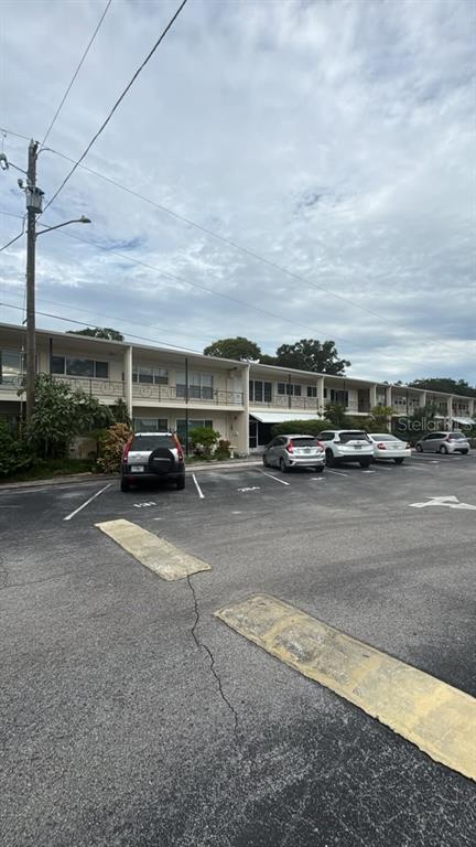 An open white linen closet stands next to a bathroom with a toilet and tub — 4032 57TH STREET N UNIT 264, KENNETH CITY, FL