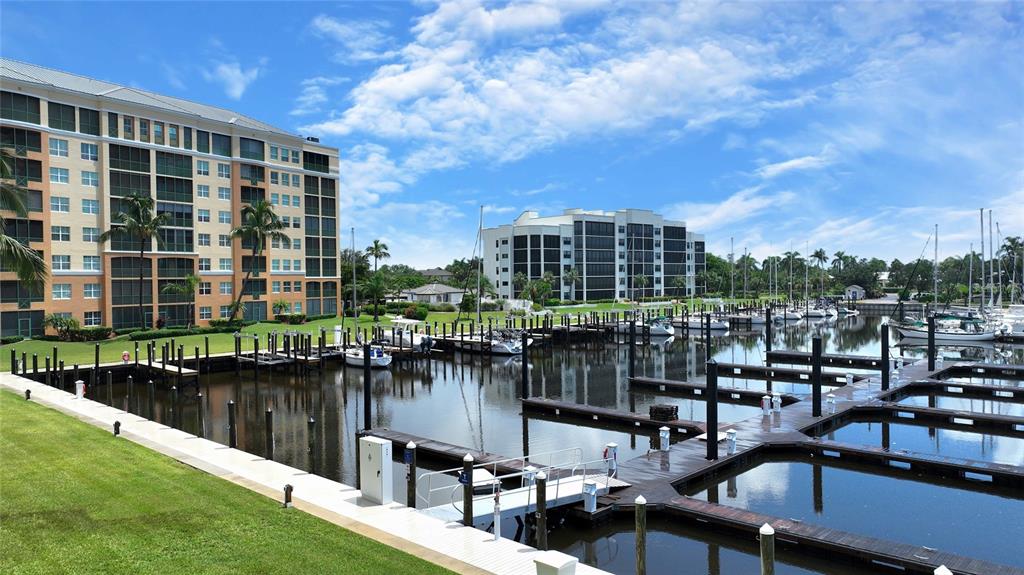 A marina with multiple boat slips sits in front of two large residential apartment buildings — 2060 MATECUMBE KEY ROAD UNIT 2402, PUNTA GORDA, FL