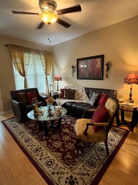 A living room features a dark leather sofa, a patterned armchair, and a glass coffee table — 1910 E PALM AVENUE UNIT 10303, TAMPA, FL