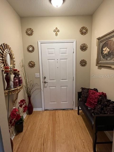 An entryway features a white door, wood flooring, a bench, and decorative wall accents — 1910 E PALM AVENUE UNIT 10303, TAMPA, FL