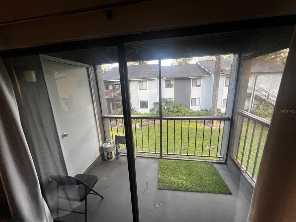 A screened-in balcony with a concrete floor, a small patch of artificial turf, and railings — 202 RIVERBEND DRIVE UNIT 204, ALTAMONTE SPRINGS, FL