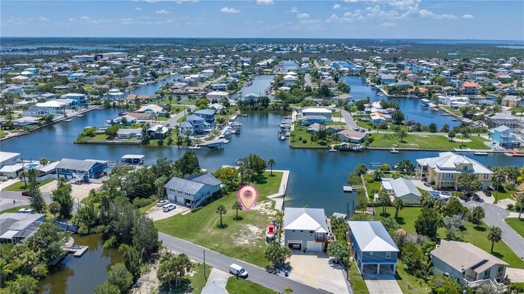 An aerial view shows a vacant waterfront lot marked with a pin in a residential neighborhood — 3616 FLAMINGO BOULEVARD, HERNANDO BEACH, FL