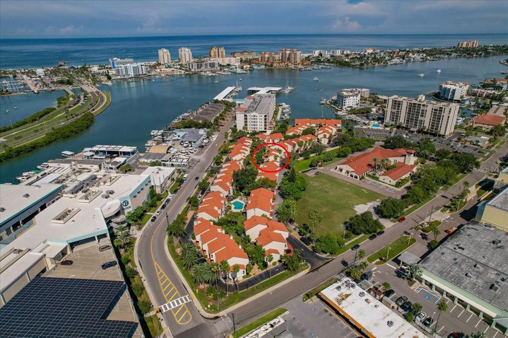 Aerial view of a coastal townhome community with red roofs and a central swimming pool — 240 WINDWARD PASSAGE UNIT 702, CLEARWATER, FL