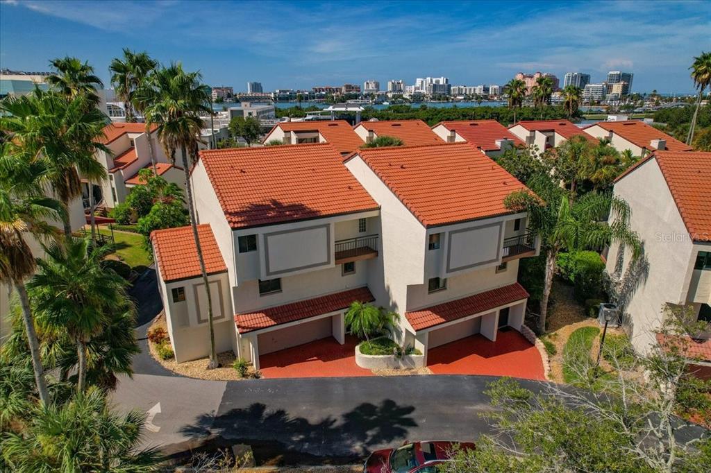An aerial view of a multi-story townhouse complex with red tile roofs and palm trees — 240 WINDWARD PASSAGE UNIT 702, CLEARWATER, FL