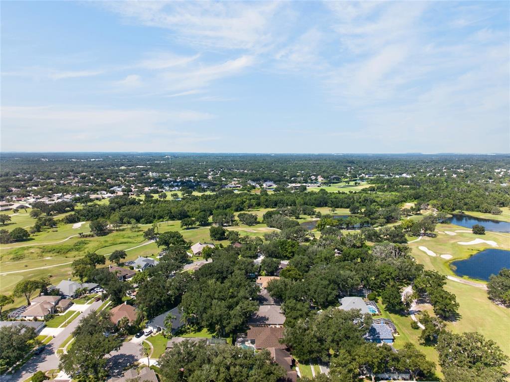 A spacious room with light-colored tile flooring, a chandelier, and a dark wood front door — 2243 EAGLE BLUFF DRIVE, VALRICO, FL