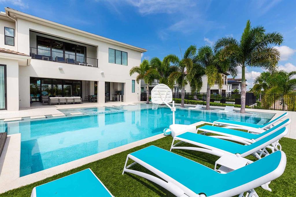 A two-story modern house with a stone-accented facade, two garage doors, and a paved driveway — 751 GOLDEN BEAR DRIVE, REUNION, FL