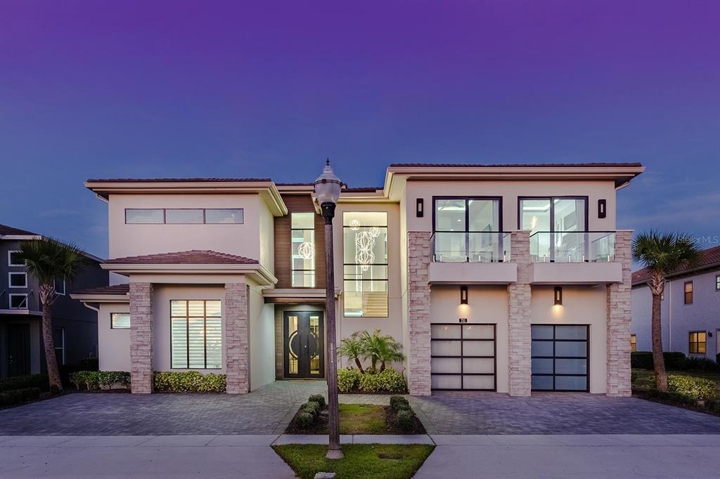 A modern two-story house features a swimming pool with lounge chairs on a grassy deck — 751 GOLDEN BEAR DRIVE, REUNION, FL