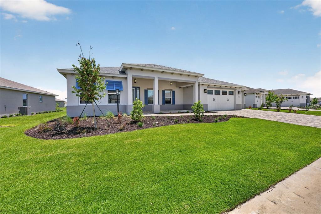 A single-story house with a paved driveway, blue shutters, and a landscaped front yard — 10260 SW 84TH STREET ROAD, OCALA, FL