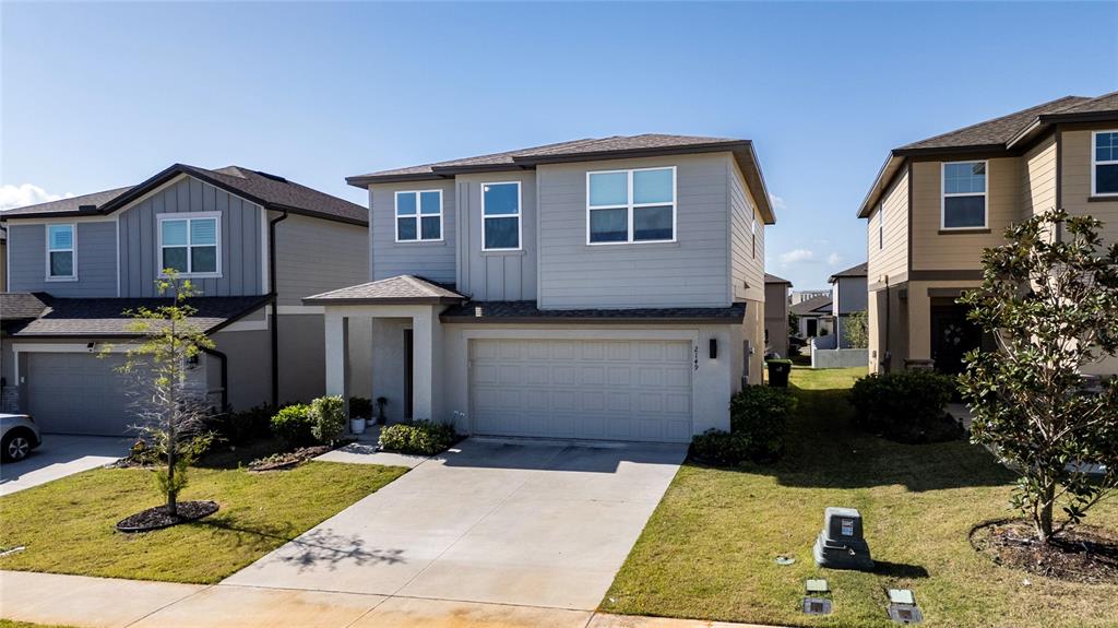 A two-story suburban house with a gray exterior, a two-car garage, and a concrete driveway — 2149 TREASURE HILL STREET STREET, MINNEOLA, FL